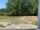 Picture of unfinished backyard with piles of dirt and green trees at 1395 Knotty Branch Rd., Conway, SC 29527