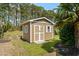 A storage shed with a double door entrance and a light brown exterior at 152 Shenandoah Dr., Murrells Inlet, SC 29576