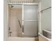 Well-lit bathroom featuring a shower and bath with sliding glass doors at 1581 S Waccamaw Dr. # 303, Murrells Inlet, SC 29576