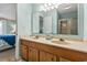 Bright bathroom featuring a dual sink vanity and large mirror, conveniently located near the bedroom at 1581 S Waccamaw Dr. # 303, Murrells Inlet, SC 29576