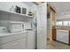 Laundry room featuring washer, dryer, shelves, and access to kitchen appliances at 1581 S Waccamaw Dr. # 303, Murrells Inlet, SC 29576