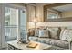 Cozy living room with a floral sofa, coffee table, and balcony access at 1581 S Waccamaw Dr. # 303, Murrells Inlet, SC 29576