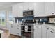 Well-equipped kitchen with stainless steel appliances, white cabinets, and stylish backsplash at 2105 Ballast Ct., Myrtle Beach, SC 29579