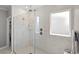 Modern shower with white marble-style tiling, a glass enclosure, and sleek fixtures enhancing the bathroom's elegance at 2105 Ballast Ct., Myrtle Beach, SC 29579