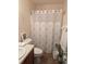 Well-maintained bathroom with coral shower curtain, white fixtures, and a small potted plant for decoration at 320 Mckaylas Ct., Myrtle Beach, SC 29579