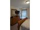Well-lit bedroom featuring wooden dresser with mirror and TV, complemented by decorative plants and natural lighting at 320 Mckaylas Ct., Myrtle Beach, SC 29579