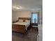 Cozy bedroom with wooden bed frame, bedside tables with lamps, and a window providing natural light at 320 Mckaylas Ct., Myrtle Beach, SC 29579