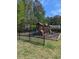 Community playground with multiple slides and wood mulch, surrounded by green grass and mature trees at 320 Mckaylas Ct., Myrtle Beach, SC 29579