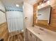 Well-lit bathroom boasts wood accents, a vanity, and a shower-tub combo at 400 Melrose Pl. # 14-A, Myrtle Beach, SC 29572