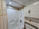 Bathroom shower with tiled accent wall, storage cabinet, and modern fixtures at 400 Melrose Pl. # 14-A, Myrtle Beach, SC 29572