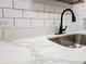 Close-up of a kitchen counter featuring a stylish sink, black faucet, and marble-look countertops at 400 Melrose Pl. # 14-A, Myrtle Beach, SC 29572