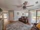 Comfortable living room featuring a ceiling fan, a leather sofa, and access to kitchen and deck at 400 Melrose Pl. # 14-A, Myrtle Beach, SC 29572