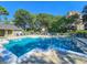 Inviting pool with clear blue water and poolside lounge chairs, set amidst lush trees and a sunny sky at 400 Melrose Pl. # 14-A, Myrtle Beach, SC 29572