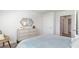 Bright bedroom featuring light blue bedding, light wood dresser, and decorative mirror at 598 Strawberry Field Way, Galivants Ferry, SC 29544