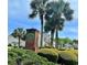 Merritt Park community sign featuring a brick base, lush landscaping, and towering palm trees against a clear blue sky at 100 Barnacle Ln. # S-4, Little River, SC 29566