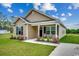 Charming tan home with lush front lawn and covered porch, enhanced by a sunny, partly cloudy sky at 1390 Highway 129, Galivants Ferry, SC 29544