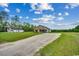 A long driveway leads to a charming home with a lush green front yard under a partly cloudy sky at 1390 Highway 129, Galivants Ferry, SC 29544
