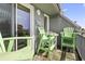 The balcony has Adirondack chairs, a table and a sign hanging on the wall that says, 