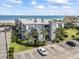 Aerial view of the condo complex, beach, and parking lot on a bright sunny day at 1501 S Waccamaw Dr. # 3-L, Murrells Inlet, SC 29576