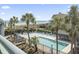 Elevated view of a community pool surrounded by lounge chairs, palm trees and with ocean view at 1501 S Waccamaw Dr. # 3-L, Murrells Inlet, SC 29576
