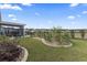 Expansive backyard featuring a screened-in patio, lush landscaping, and a well-maintained lawn at 1612 Cosmos Lane, Myrtle Beach, SC 29577