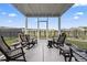 Inviting screened-in patio featuring rocking chairs and a view of the well-maintained yard and landscaping at 1612 Cosmos Lane, Myrtle Beach, SC 29577