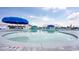 Community pool with lounge chairs and blue umbrellas, offering a relaxing recreational space at 1612 Cosmos Lane, Myrtle Beach, SC 29577
