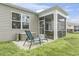 Inviting backyard with a screened porch, a patio with lounge chairs, and a well-maintained lawn surrounded by greenery at 2904 Lunar Ct., Myrtle Beach, SC 29577