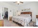 Cozy bedroom featuring a floral-patterned quilt, ceiling fan, and convenient access to the ensuite bathroom and walk-in closet at 2904 Lunar Ct., Myrtle Beach, SC 29577