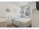 Bright bedroom with a white iron frame bed, complemented by matching nightstands and a well-lit window at 2904 Lunar Ct., Myrtle Beach, SC 29577