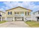 Inviting raised beach house featuring a light yellow exterior and a welcoming, covered entry at 308 36Th Ave. N, North Myrtle Beach, SC 29582