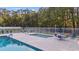 Community pool and hot tub area surrounded by lounge chairs, tables, umbrellas, and white fence at 3255 Gervais Ln., Myrtle Beach, SC 29588