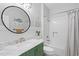Stylish bathroom with a green vanity, a round mirror, a bathtub, and subway tile at 441 Garden Ave., Georgetown, SC 29440