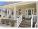 Inviting front porch with brick steps, white railings, and plants offers a charming welcome to this cozy home at 441 Garden Ave., Georgetown, SC 29440