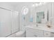 Bright bathroom with a shower-tub combo, white vanity, and a unique round window for natural light at 601 Hillside Dr. N # 2305, North Myrtle Beach, SC 29582