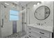 Bathroom with updated shower and modern vanity with decorative round mirror at 613 Cypress Dr., Surfside Beach, SC 29575