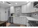 Contemporary kitchen with a stainless steel dishwasher, white cabinets, and mosaic tile backsplash at 613 Cypress Dr., Surfside Beach, SC 29575