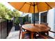 Outdoor patio with round wooden table under an umbrella, surrounded by greenery and a privacy fence at 72 Landing Rd. # 0, Pawleys Island, SC 29585