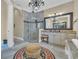 Bright bathroom with decorative chandelier, patterned rug, glass shower and a vanity with a granite countertop at 9243 Marina Pkwy., Myrtle Beach, SC 29572