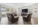 A bright living room with a large TV, leather furniture, and sliding glass doors to the backyard at 1101 Bronwyn Circle, North Myrtle Beach, SC 29582