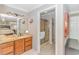 A bright bathroom features granite counters, wood cabinetry, and an open doorway to a shower at 111 Hickory Dr., Conway, SC 29526