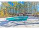 Community pool with a secure cover and a nearby lounging area surrounded by tall trees on a sunny day at 111 Hickory Dr., Conway, SC 29526