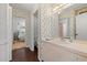 A well-lit bathroom with a floral wallpaper, white vanity, and a view into a bedroom at 1213 Oak St., Conway, SC 29526