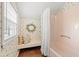 Bright bathroom featuring a tub with shower, window seat and decorative floral wallpaper at 1213 Oak St., Conway, SC 29526