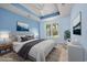 Stylishly staged bedroom with a tray ceiling, soft blue walls, and a picturesque window view at 1501 Palmina Loop # B, Myrtle Beach, SC 29588