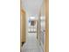 Hallway leading to a kitchen with white cabinetry, appliances, and a tiled floor at 1604 N Ocean Blvd. # 904, Myrtle Beach, SC 29577