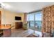 Comfortable seating in living area with large windows leading to balcony, with television at 1604 N Ocean Blvd. # 904, Myrtle Beach, SC 29577