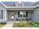 Cozy front porch featuring stylish seating, a decorative door, and well-maintained landscaping at 1794 Graham Rd., Aynor, SC 29544