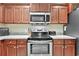 Close-up of modern kitchen appliances, granite counters, and rich, dark wood cabinetry at 1794 Graham Rd., Aynor, SC 29544