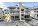 A three story condo building with a light grey exterior, multiple balconies, and parking underneath the units at 1801 N Ocean Blvd. # O-4, North Myrtle Beach, SC 29582
